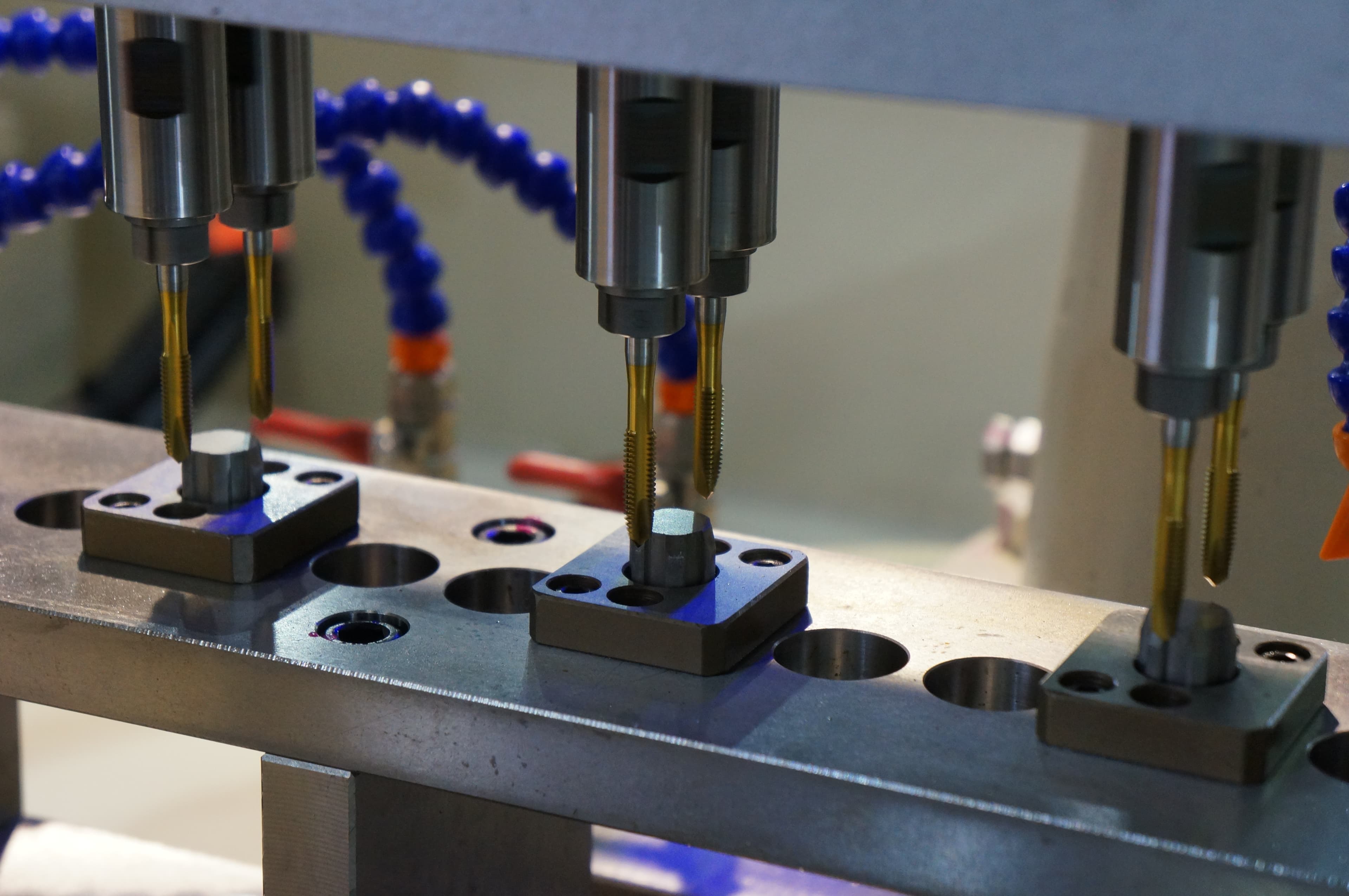 Precision drilling and threading of production parts with gauging and burr control